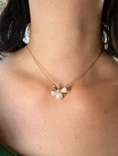 Gold bow pearl pendant necklace with mother of pearl worn on model
