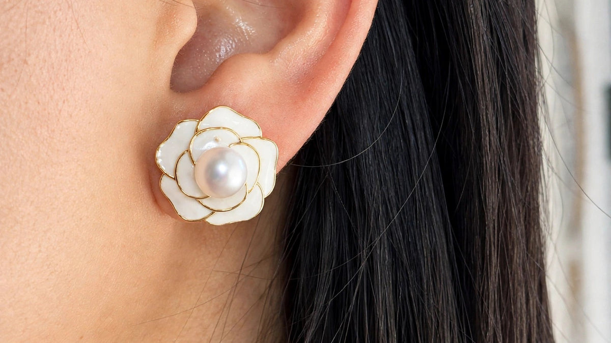 Gold camellia flower pearl stud earring worn on model
