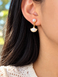 Gold ginkgo leaf pearl drop earring worn on model, enhanced