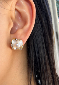 Gold shell pearl stud earring with mother of pearl worn on model