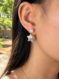 Gold star pearl drop earring with mother of pearl worn on model