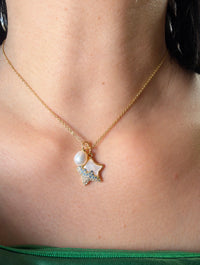 Gold star pearl pendant necklace with mother of pearl worn on model