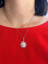 White gold plated sunburst pearl pendant necklace worn on model