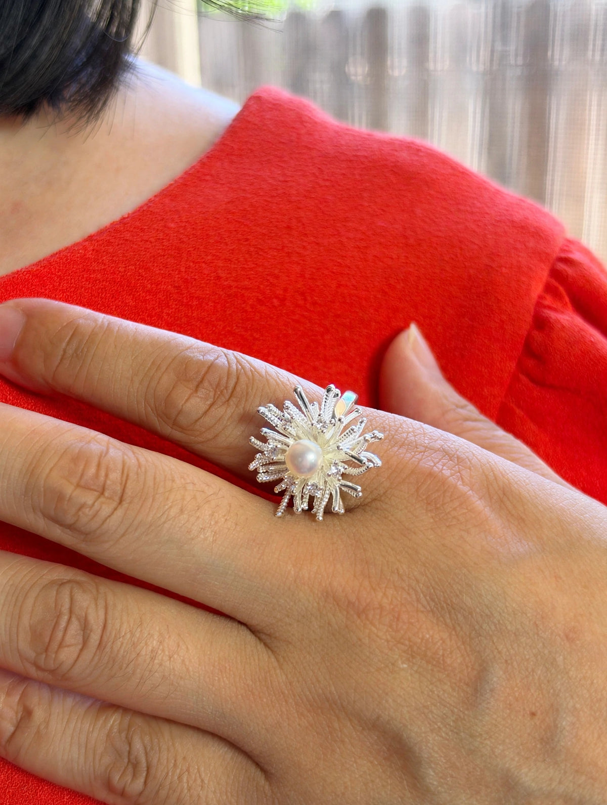 White gold plated sunburst pearl ring worn on model hand
